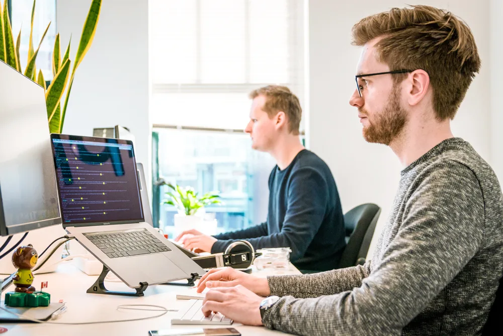 Two colleagues working at computer workstations in an office